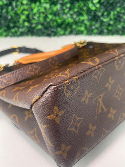 Bottom corner view of brown and tan monogram canvas of a preowned Louis Vuitton Marignan handbag.