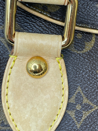 Zoomed in photo of leather chap and gold hardware a preowned Louis Vuitton Monogram Beverly GM handbag with a brown and beige color scheme, featuring the brand's iconic LV logo.