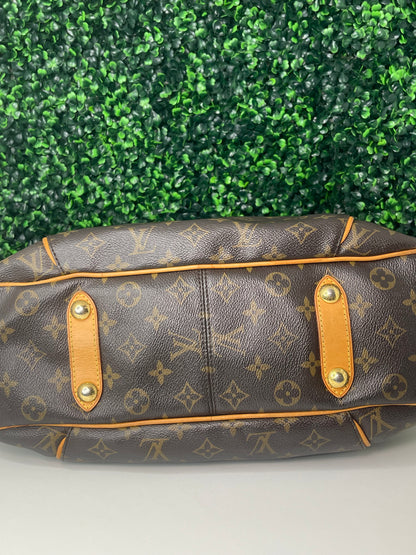 Bottom view of a brown monogram Preowned Louis Vuitton Galliera PM with gold hardware.