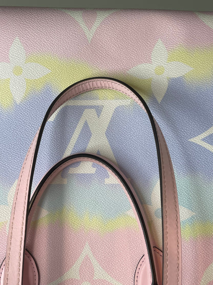 Two pink leather handle straps on a pink and multicolor canvas Louis Vuitton OnTheGo Escale handbag GM.  
