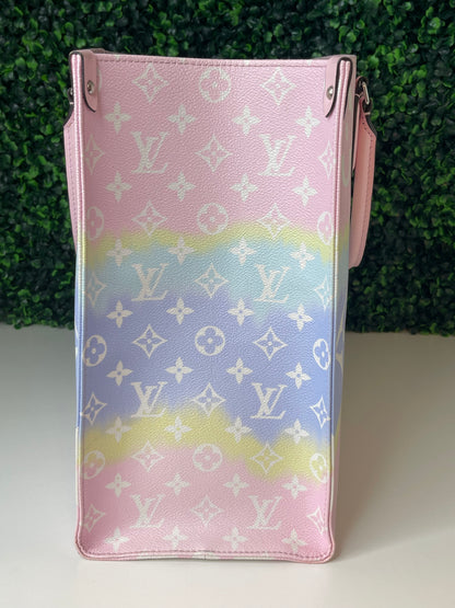 Side view of a pink and multicolor patterned Louis Vuitton OnTheGo Escale handbag GM with a structured handle and straps.