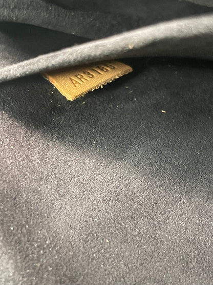 Interior view from outside looking into canvas slip pocket and leather date code of a preowned Louis Vuitton Marignan handbag. 