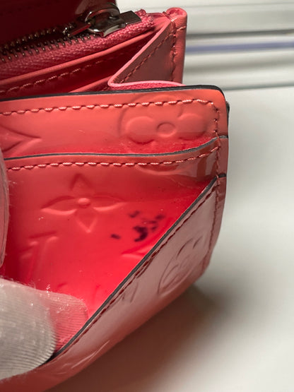 Interior view of a card slot with some color transfer in corner of preowned Louis Vuitton long wallet with vernis leather. 