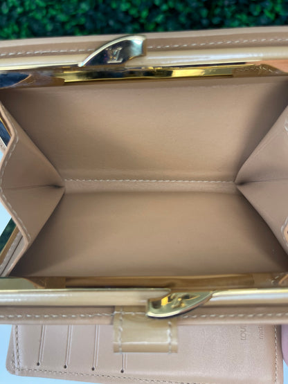 Interior view of a preowned Louis Vuitton tan vernis leather wallet with a monogram pattern and a tan leather interior, featuring a lock and key mechanism.