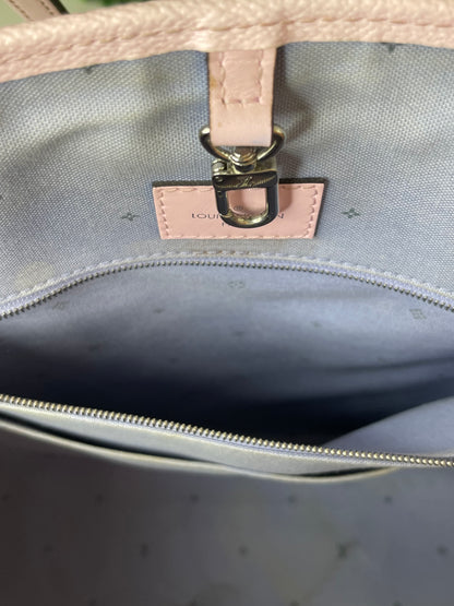 Zoomed in image of zipper pocke with purple-blue cloth interior of patterned Louis Vuitton OnTheGo Escale handbag GM. 