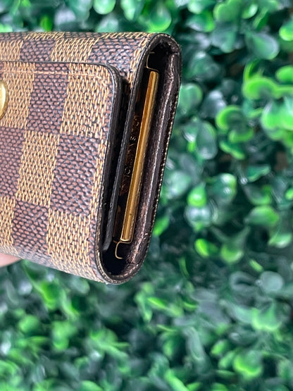 Side edge of a preowned Louis Vuitton Damier Ebene Multicles 4 Key Holder with brown damier canvas and gold-tone hardware.