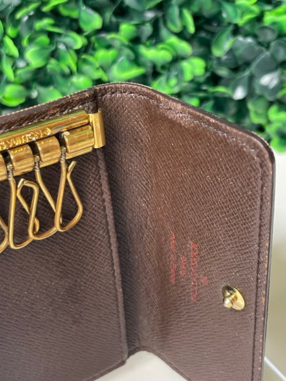 Interior view of brown canvas of a preowned Louis Vuitton Damier Ebene Multicles 4 Key Holder with brown damier canvas and gold-tone hardware.