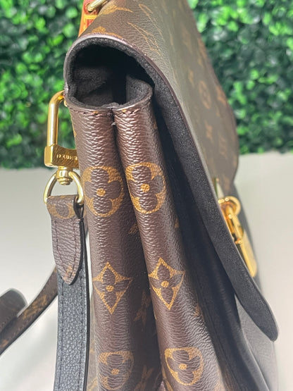 View from the left side of a preowned Louis Vuitton Marignan handbag in black color with a brown handle and a gold-tone hardware.