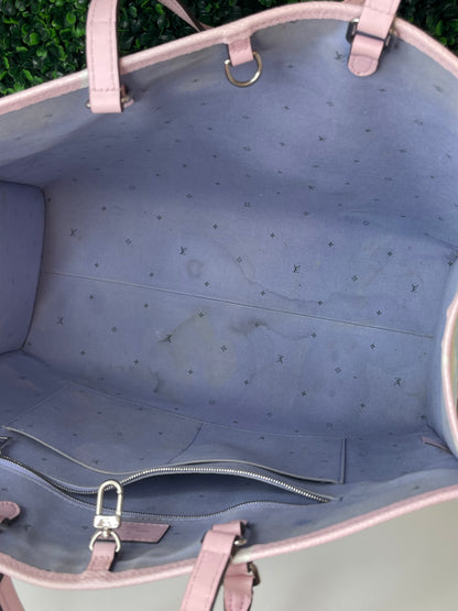 Zoomed in image of top interior with purple-blue cloth interior of patterned Louis Vuitton OnTheGo Escale handbag GM. Shows some staining on interior. 