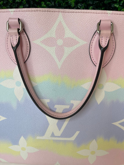 Zoomed in image of a pink and multicolor patterned Louis Vuitton OnTheGo Escale handbag GM with a structured handle and straps.