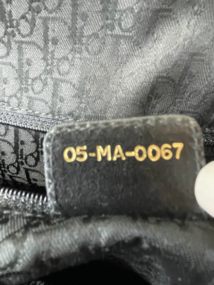 Heat stamp number code on back side of leather tab on interior of preowned Dior black leather handbag.