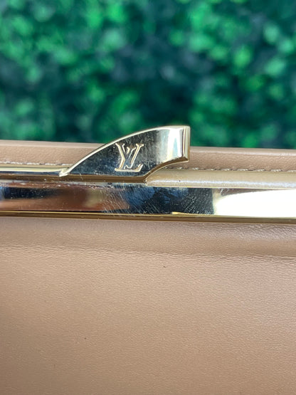 Gold hardware with LV emblem on kisslock coin pouch of a preowned Louis Vuitton tan vernis leather wallet.