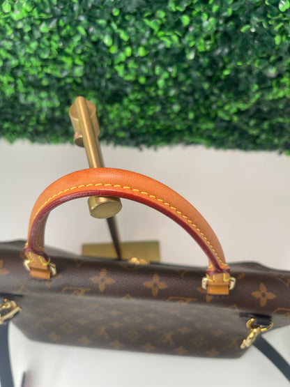A preowned Louis Vuitton Marignan handbag in black color with a brown handle and a gold-tone hardware. Image shows zoomed in photo of leather top handle. 