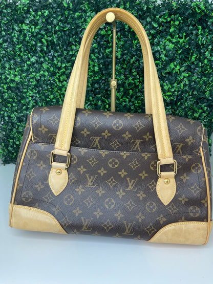 The backside view of a preowned Louis Vuitton Monogram Beverly GM handbag with a brown and beige color scheme, featuring the brand's iconic LV logo, tan leather trim, displayed against a green-tone background.