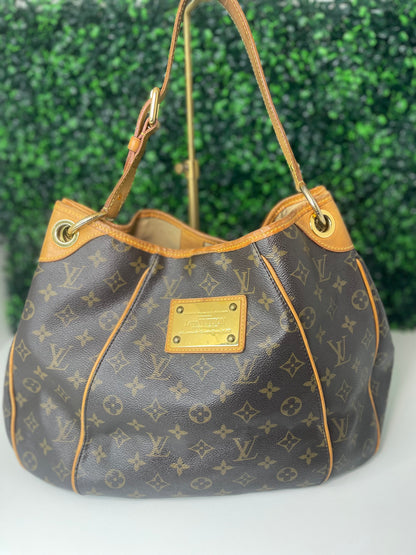 Front view of a brown monogram Preowned Louis Vuitton Galliera PM with gold hardware.