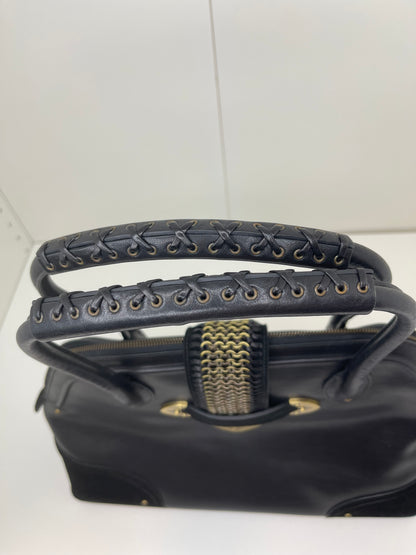 Top handle view a preowned Dior black leather handbag with black suede trim and aged brass hardware, featuring a braided top handle.
