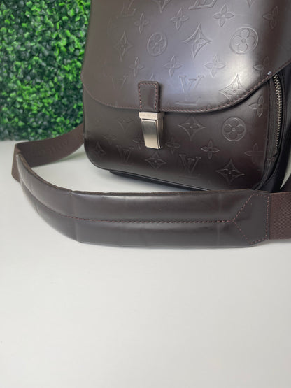 View is of brown handbag and cloth strap 