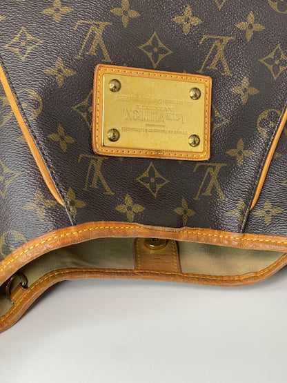 Front view of brown monogram Preowned Louis Vuitton Galliera PM with gold hardware plate and leather trim.