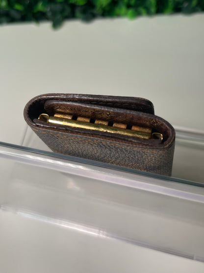 Bottom view of a preowned Louis Vuitton Damier Ebene Multicles 4 Key Holder with brown damier canvas and gold-tone hardware.