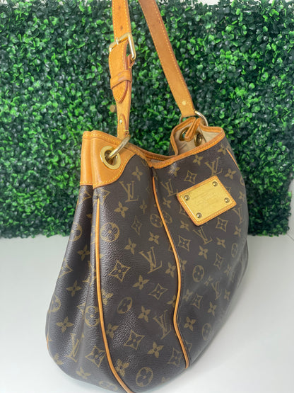 Left side view of a brown monogram Preowned Louis Vuitton Galliera PM with gold hardware.