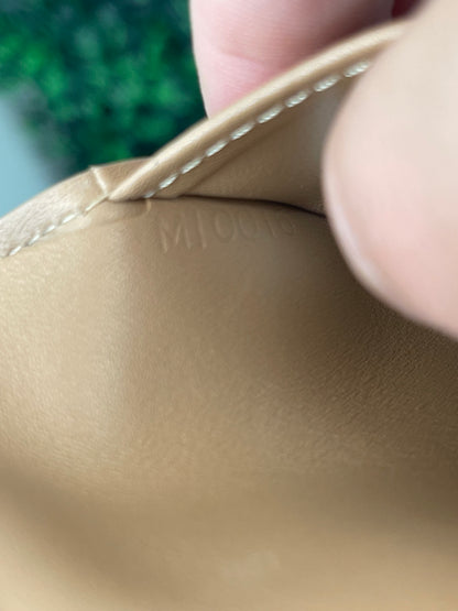 Date code embossed on interior picket of a preowned Louis Vuitton tan vernis leather wallet. 