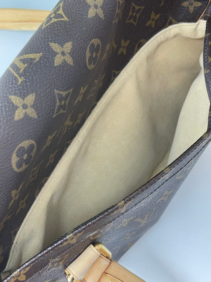 Interior slip pocket with tan suede material on the back side of a preowned Louis Vuitton Monogram Beverly GM handbag with a brown and beige color scheme, tan leather trim, featuring the brand's iconic LV logo.