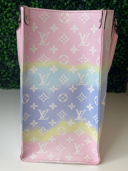 Side view of a pink and multicolor patterned Louis Vuitton OnTheGo Escale handbag GM.