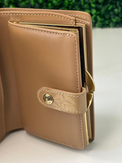 Interior view of a preowned Louis Vuitton tan vernis leather wallet with a monogram pattern and a tan leather interior, featuring a lock and key mechanism.