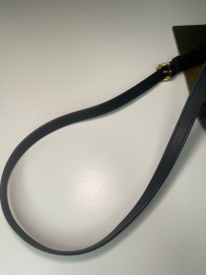 Shows black leather strap of the preowned Louis Vuitton Marignan handbag in black color with a brown handle and a gold-tone hardware.
