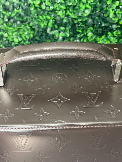 Brown handbag showing top and handle of the bag