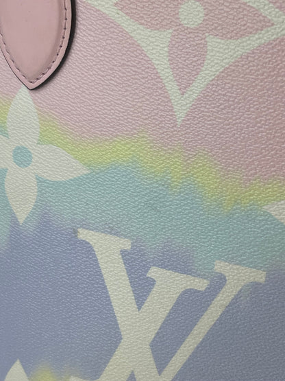 Zoomed in image of a pink and multicolor patterned Louis Vuitton OnTheGo Escale handbag GM with a structured handle and straps.